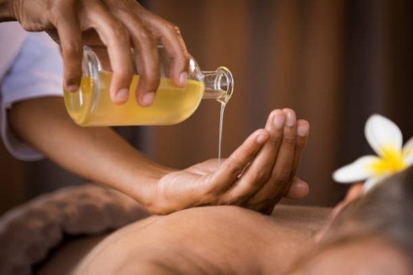 istockphoto-994810170-612×612 Closeup of masseur hands pouring aroma oil on woman back. Masseuse prepare to do oriental spa procedure for relaxing treatment. Therapist doing aromatherapy oil massage on woman body.